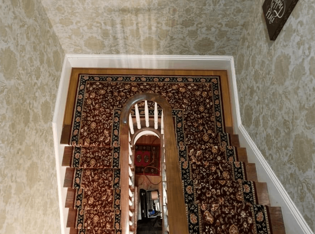Overhead view of the same pattern-matched stair runner continuing through an arched landing